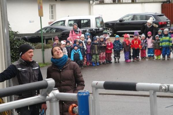 Lena Frey (Leiterin Kindergarten Pfistergässle) und Siegfried Buderer, im Hintergrund die Kinder mit Betreuerinnen.