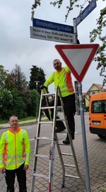 Foto v.l.n.r.: Christian Bühler und Matthias Nübling, Verbandsbauhof, montieren das Zusatzschild mit QR-Code zur "Hindenburgstraße" Foto v.l.n.r.: Christian Bühler und Matthias Nübling, Verbandsbauhof, montieren das Zusatzschild mit QR-Code zur "Hindenburgstraße"