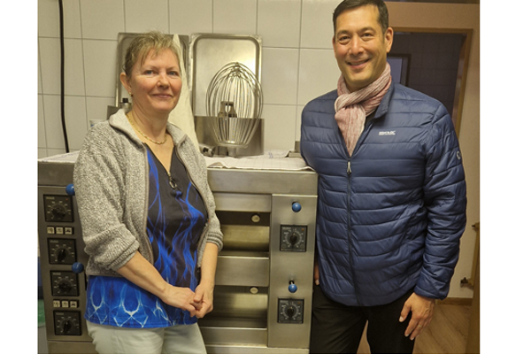 Inhaberin Valeria Ortner und Bürgermeister Markus Hollemann vor einer Küchenmaschine
