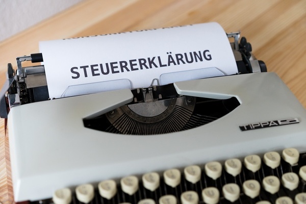 graue Schreibmaschine mit eingespanntem Formular "Steuererklärung"