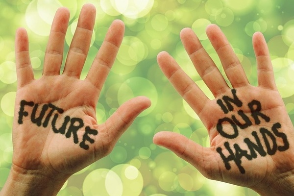 Zwei H&auml;nde vor gr&uuml;nem Hintergrund. Schwarze Schrift auf Handinnenfl&auml;chen