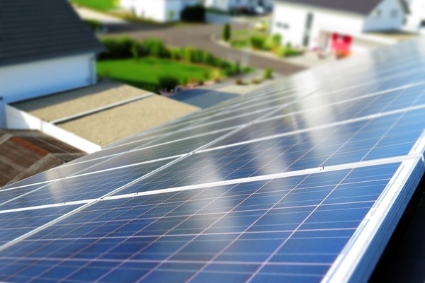 Blick vom Dach eines Wohngebäudes hinunter und über ein schwarzes PV-Modul Blick vom Dach eines Wohngebäudes hinunter und über ein schwarzes PV-Modul