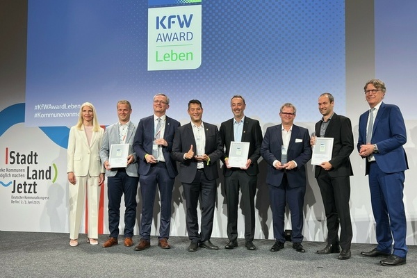 Der Denzlinger B&uuml;rgermeister Markus Hollemann (Mitte l.) u K&auml;mmerer Martin Ziegler (Mitte r.) repr&auml;sentieren Denzlingen bei d. Verleihung d. KfW Awards Leben 2025. Links: KfW-Vorst&auml;ndin Melanie Kehr, rechts Stefan Wintels, Vorstandsvorsitzender der KfW