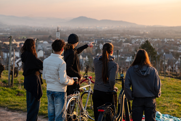 Eine Gruppe Jugendlicher mit Fahrrädern blicken über die Gemeinde Denzlingen. Foto: Peter Herrmann / Gemeinde Denzlingen