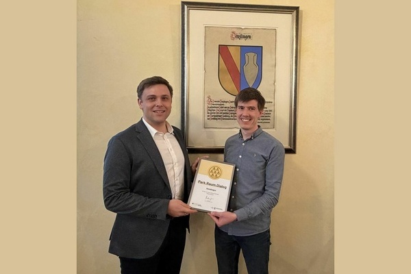 Fabian Meurer vom Kompetenznetz KLIMA MOBIL &uuml;berreicht das Zertifikat Park.Raum.Dialog an B&uuml;rgermeister Fabian Nitz. Foto: Gemeinde Denzlingen