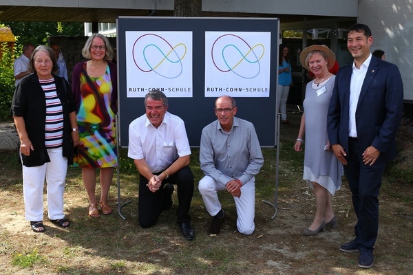 Die Schulleiter Berthold Fletschinger und Tobias Barth pr&auml;sentieren das neue Schullogo umrahmt von Andrea Friske und Irene Klein vom Ruth Cohn Institut sowie Christel Bohlen und B&uuml;rgermeister Markus Hollemann