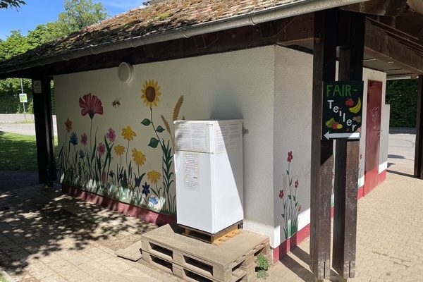 Fair-Teiler Kühlschrank an der Rückseite des Häuschens der Bushaltestelle beim Sport & Familienbad MACH' BLAU